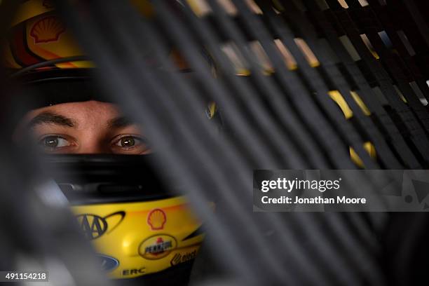 Joey Logano, driver of the Shell Pennzoil Ford, sits in his car in the garage area during practice for the NASCAR Sprint Cup Series AAA 400 at Dover...