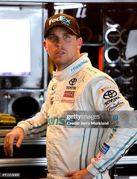 Denny Hamlin, driver of the FedEx Office Toyota, looks on in the garage area during practice for the NASCAR Sprint Cup Series AAA 400 at Dover...