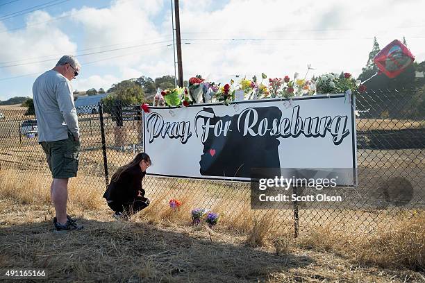 Dave and Robin Griffiths leave flowers at a memorial along the road to Umpqua Community College on October 3, 2015 in Roseburg, Oregon. On Thursday...