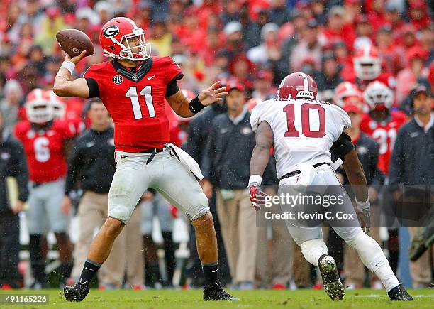 Greyson Lambert of the Georgia Bulldogs looks to pass against Reuben Foster of the Alabama Crimson Tide at Sanford Stadium on October 3, 2015 in...