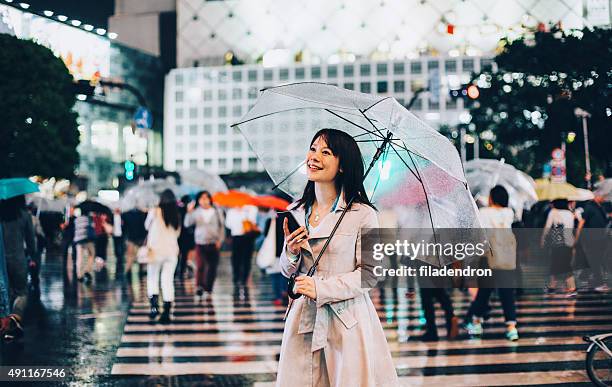 japanische frau draußen im regen - female with umbrella stock-fotos und bilder