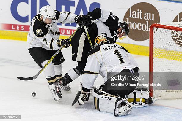 Bradley Kennedy of the Charlottetown Islanders defends against Miguel Picard of the Blainville-Boisbriand Armada near goaltender Mason McDonald...