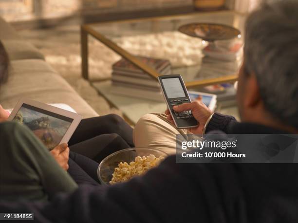 a family watching a film streamed from and tablet computer - couple at table with ipad stockfoto's en -beelden