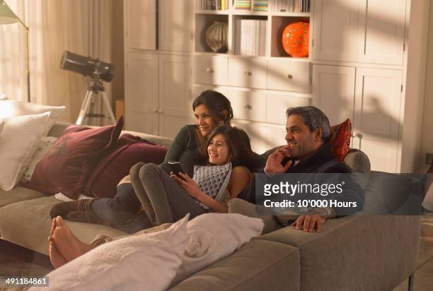 a family watching television - indian couple at home stock-fotos und bilder