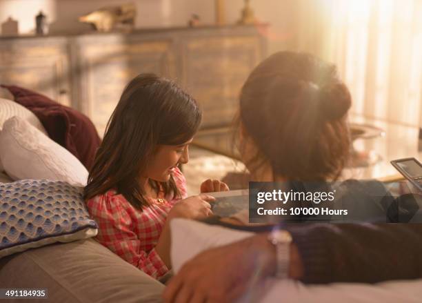 a girl showing her parents something on an tablet computer - indian couple at home stock-fotos und bilder