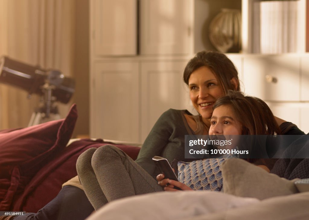 A mother and daughter watching television