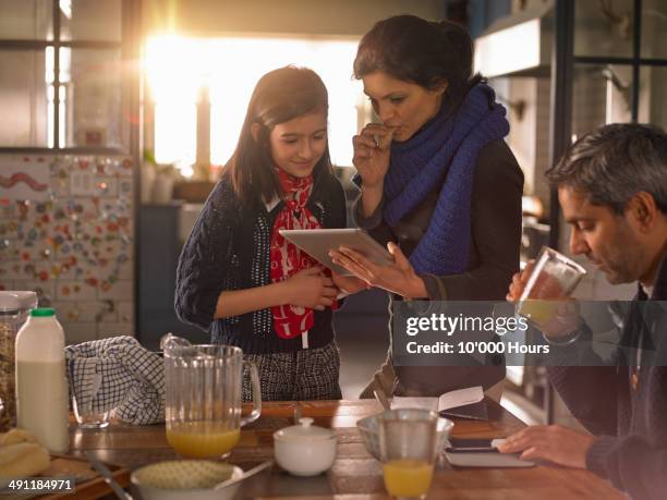 mother and daughter at breakfast looking at tablet computer - indian mother and child stock pictures, royalty-free photos & images