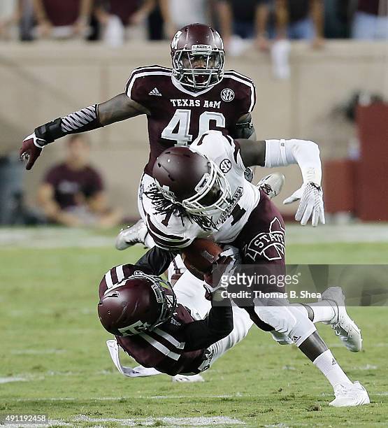 De'Runnya Wilson of the Mississippi State Bulldogs is tackled by De'Vante Harris of the Texas A&M Aggies in the second quarter on October 3, 2015 at...
