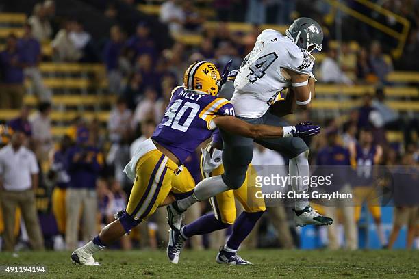 Shaq Vann of the Eastern Michigan Eagles is tackled by Duke Riley of the LSU Tigers at Tiger Stadium on October 3, 2015 in Baton Rouge, Louisiana.