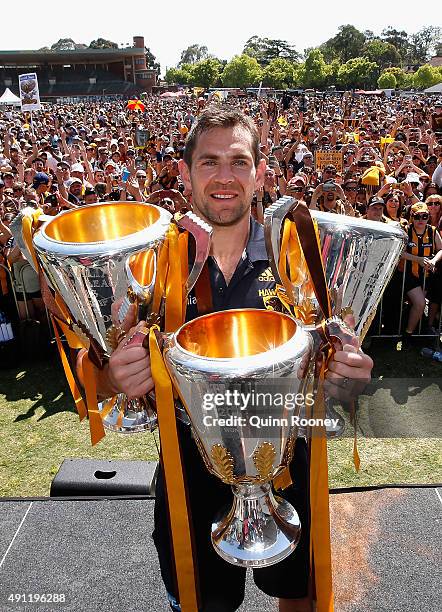 Luke Hodge the captian of the Hawks poses with the 2013, 2014 and 2015 premiership trophies during the Hawthorn Hawks AFL Grand Final fan day at...