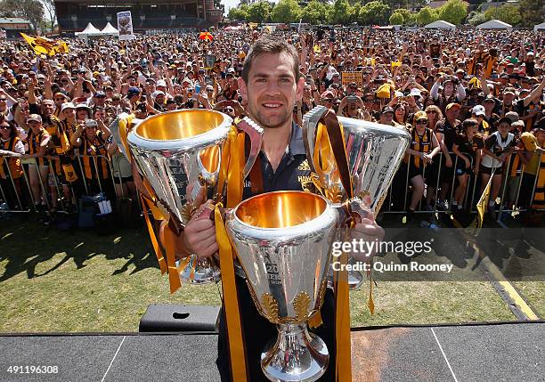 Luke Hodge the captian of the Hawks poses with the 2013, 2014 and 2015 premiership trophies during the Hawthorn Hawks AFL Grand Final fan day at...