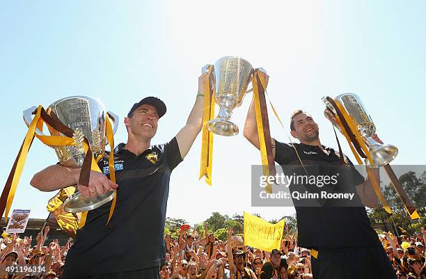 Alastair Clarkson the coach and Luke Hodge the captian of the Hawks pose with the 2013, 2014 and 2015 premiership trophies during the Hawthorn Hawks...