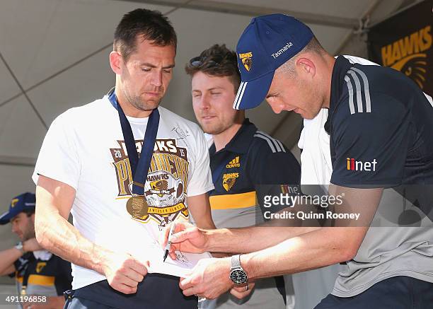 David Hale of the Hawks signs Luke Hodge's top during the Hawthorn Hawks AFL Grand Final fan day at Glenferrie Oval on October 4, 2015 in Melbourne,...