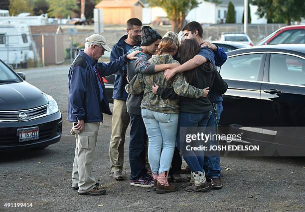 People pray near a mobile ministry vehicle during a vigil for the victims of the Umpqua Community College shooting in Winston, Oregon, on October 3,...