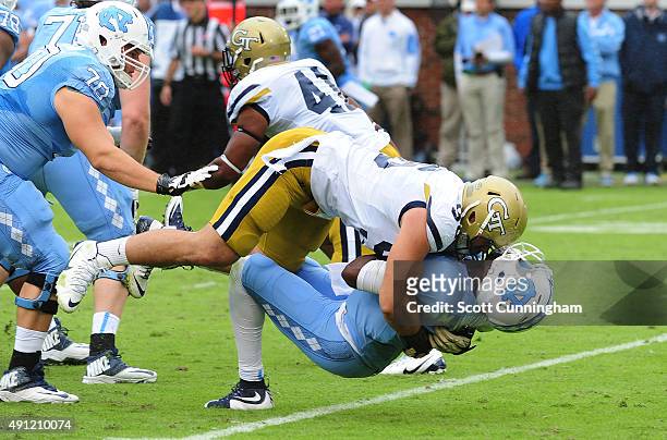 Marquise Williams of the North Carolina Tar Heels takes a hit from Adam Gotsis of the Georgia Tech Yellow Jackets on October 3, 2015 in Atlanta,...