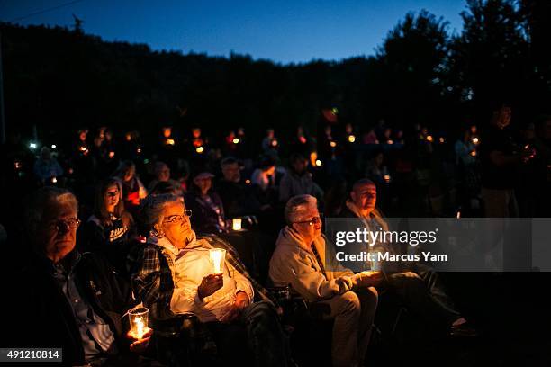 Community members attend a prayer service and candlelight vigil at River Bend Park to remember the victims of the mass shooting at Umpqua Community...