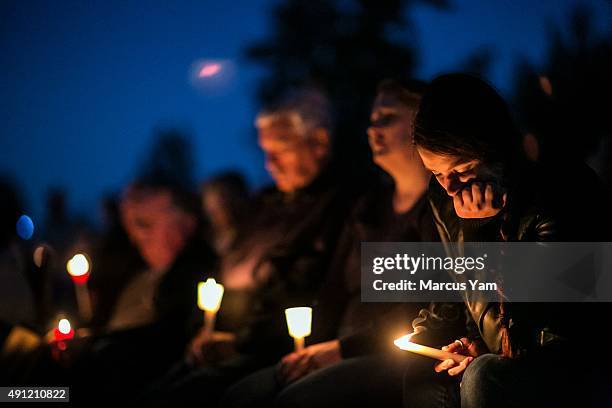 Community members attend a prayer service and candlelight vigil at River Bend Park to remember the victims of the mass shooting at Umpqua Community...