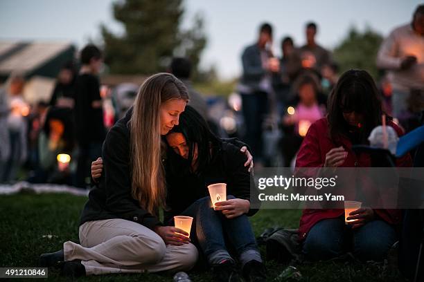 Heidi Wickersham consoles her sister, Gwendolyn Wickersham, center, a UCC student who is grieving for her creative writing mentor, the slain Lawrence...
