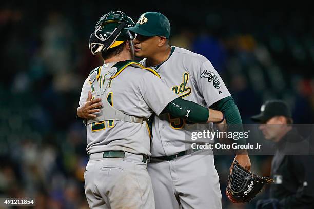 Relief pitcher Felix Doubront of the Oakland Athletics is congratulated by catcher Stephen Vogt after defeating the Seattle Mariners 7-5 in thirteen...