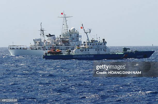 This picture taken on May 14, 2014 shows a Chinese coast guard ship sailing next to a Vietnamese coast guard vessel near China's oil drilling rig in...