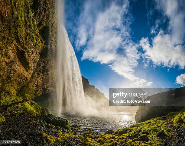 夕暮れ時の滝の流れるカスケードにのどかな山の湖 seljalandsfoss アイスランド - セリャランスフォス ストックフォトと画像