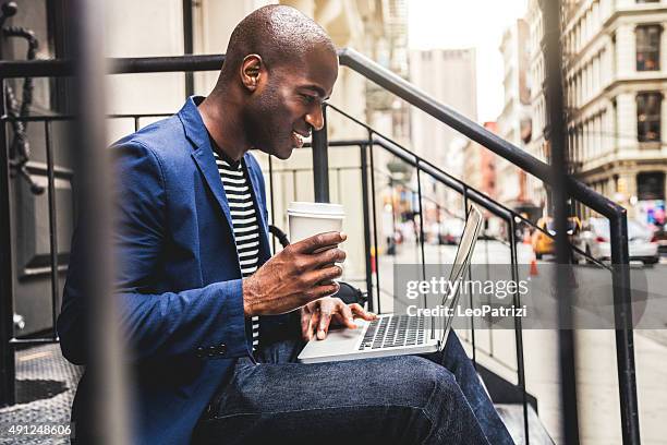 homem trocar mensagens sms no laptop sentado nas escadas na rua - pavement cafe imagens e fotografias de stock