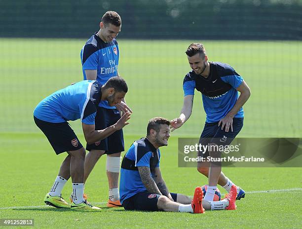 Alex Oxlade-Chamberlain, Thomas Vermaelen, Jack Wilshere and Carl Jenkinson of Arsenal joke around during a training session at London Colney on May...