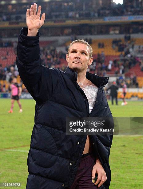 Todd Lowrie of the Broncos is seen with an injured shoulder as he waves to fans after his team are victorious after the round 10 NRL match between...