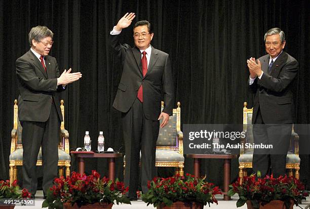 Chinese President Hu Jintao waves to audience as the lower house speaker Yohei Kono and Waseda University President Katsuhiko Shirai applaud after...