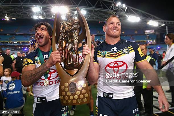 Cowboys captain Johnathan Thurston and captain Matthew Scott hold the Premiership trophy as they leave the field after winning the 2015 NRL Grand...