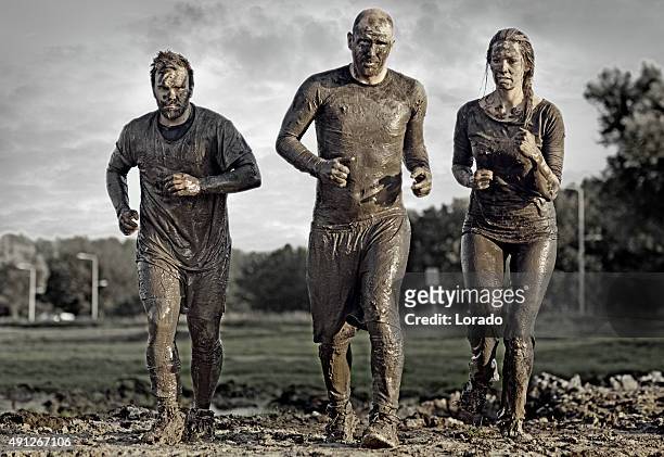 group of people jogging in mud - menselijk lichaamsdeel stockfoto's en -beelden