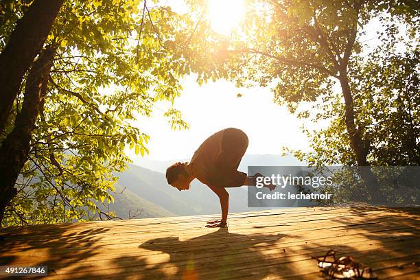 doing crane position by the beautiful view - woman stretching sunset stockfoto's en -beelden