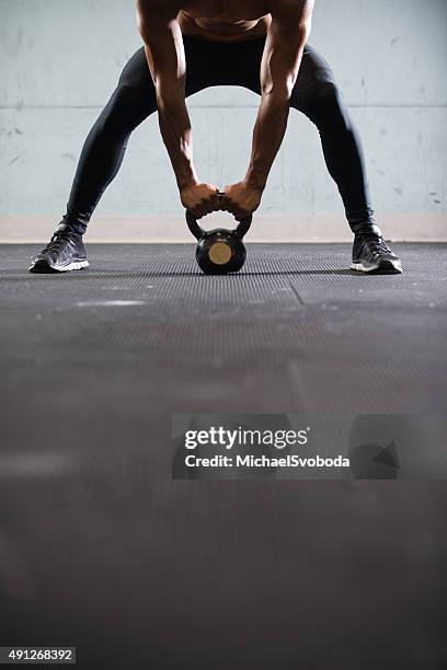 hispanic hombre trabajando con una pesa rusa - entrenamiento combinado fotografías e imágenes de stock