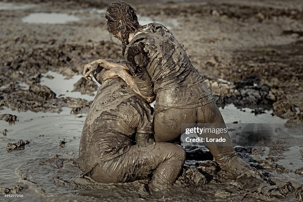 Woman getting a fight lesson in mud