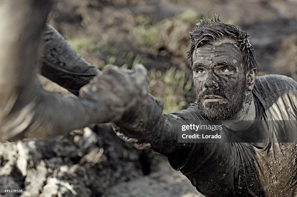Man helping his friend with getting out of mud