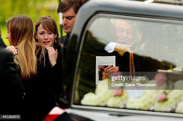 Emma Maguire, second left, and her father Don, right, hug well-wishers following the funeral of Ann Maguire at the Catholic Church of The Immaculate...