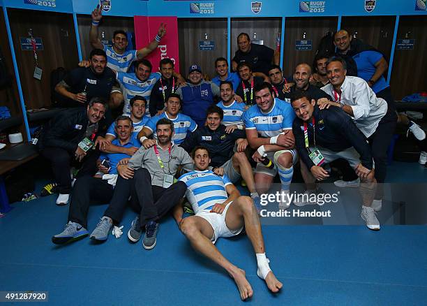 In this handout photograph provided by World Rugby via Getty Images, Diego Maradona poses with the Argentina team in the dressing room after the 2015...