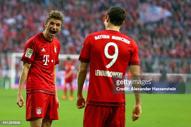 Robert Lewandowski of Muenchen celebrates scoring the 3rd team goal with his team mate Thomas Mueller during the Bundesliga match between FC Bayern...