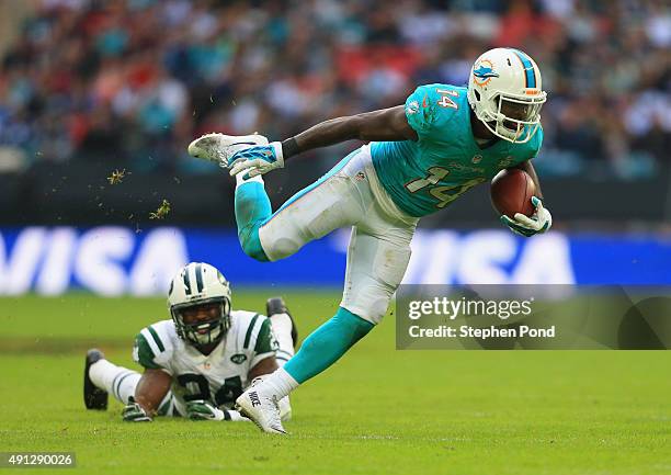 Jarvis Landry of the Miami Dolphins is tackled by Darrelle Revis of the New York Jets during the game at Wembley Stadium on October 4, 2015 in...