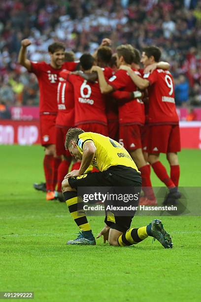 Lukasz Piszczek of Dortmund looks dejected whilst players of Muenchen celebrate the 5th team goal during the Bundesliga match between FC Bayern...