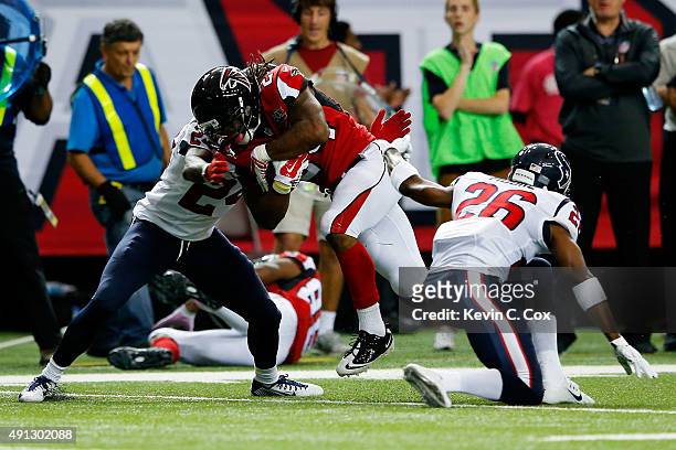 Devonta Freeman of the Atlanta Falcons is tackled after a catch by Johnathan Joseph and Rahim Moore of the Houston Texans in the first half at the...