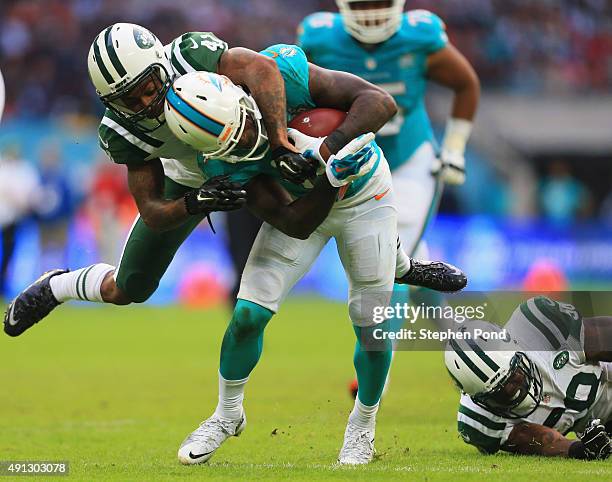 Jarvis Landry of the Miami Dolphins is tackled by Buster Skrine of the New York Jets during the game at Wembley Stadium on October 4, 2015 in London,...