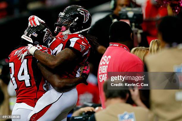 Devonta Freeman celebrates a touchdown with Roddy White of the Atlanta Falcons in the first half against the Houston Texans at the Georgia Dome on...