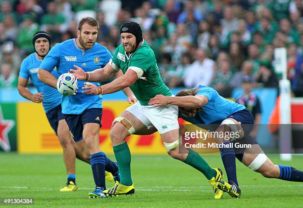 Jack McGrath of Ireland throws a pass as he is tackled during the 2015 Rugby World Cup Pool D match between Ireland and Italy at The Olympic Stadium...