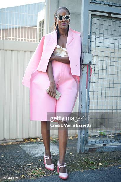 Michelle Elie poses wearing Comme des Garcons jacket and pants, Miu Miu top and Prada shoes after the Kenzo show at the Paris Event Center during...