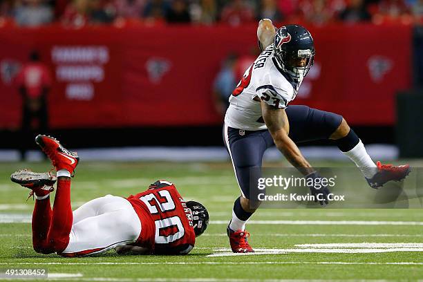 Arian Foster of the Houston Texans runs the ball past Phillip Adams of the Atlanta Falcons in the first half at the Georgia Dome on October 4, 2015...