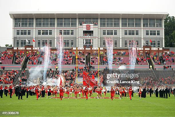 Cheerleaders of the North Carolina State Wolfpack lead their team onto the field prior to their game against the Louisville Cardinals at...