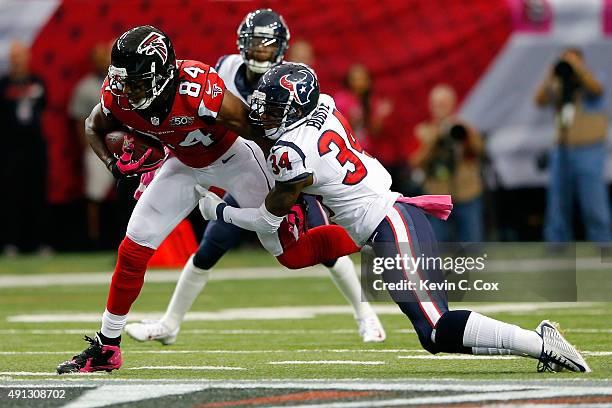 Roddy White of the Atlanta Falcons is tackled by Arian Foster of the Houston Texans in the first half at the Georgia Dome on October 4, 2015 in...