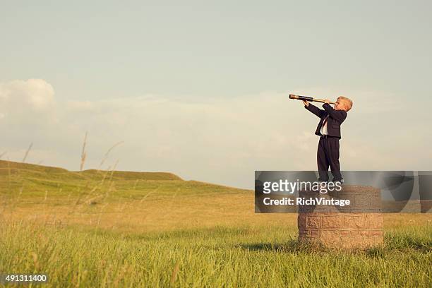 young boy businessman looking throught telescope - searching stock pictures, royalty-free photos & images