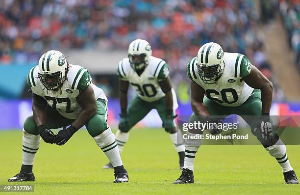 James Carpenter of the New York Jets, Darrin Walls of the New York Jets and D'Brickashaw Ferguson of the New York Jets wait at the line of scrimmage...